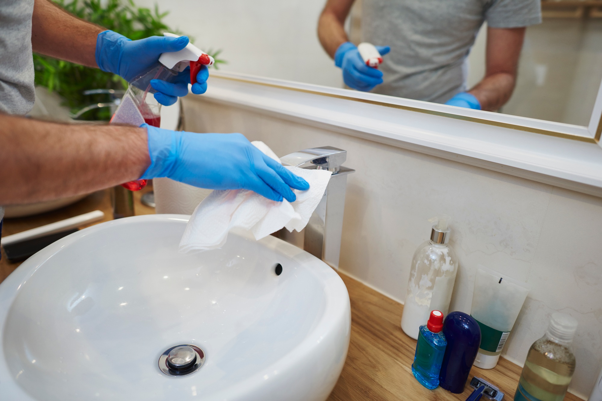 Man's hands cleaning sink in the bathroom
