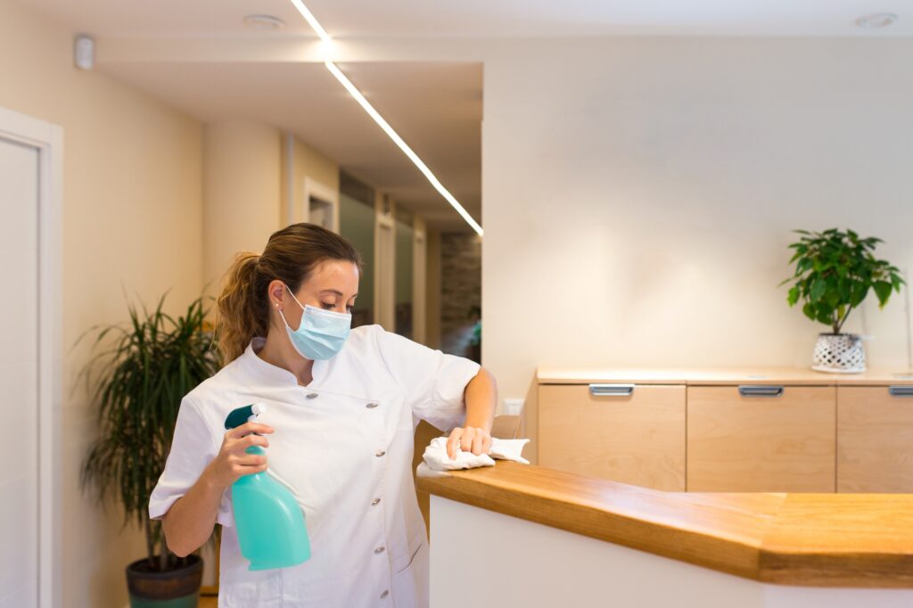 Young woman cleaning reception of physiotherapy center